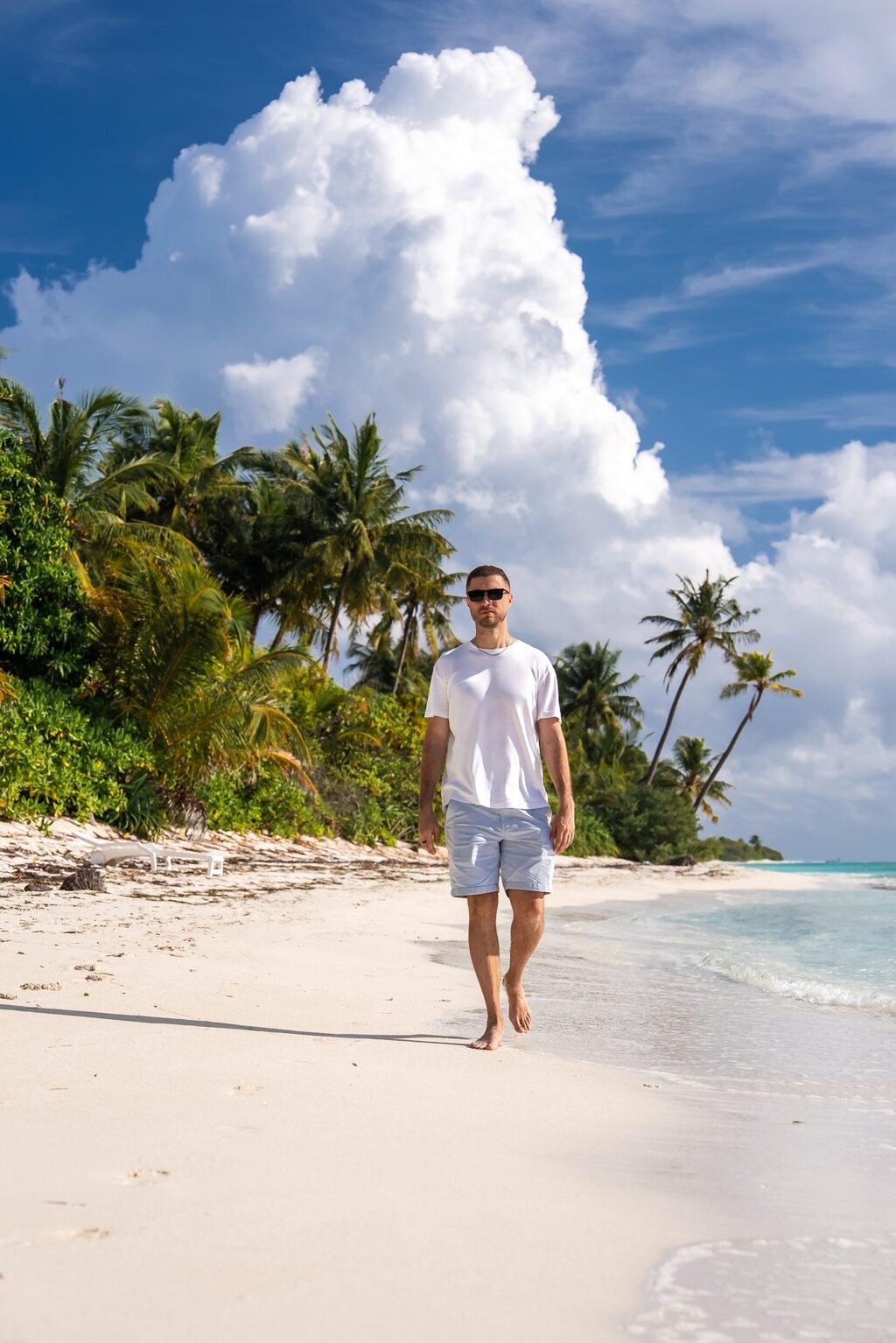A guest walking along the beach at Dhigurah