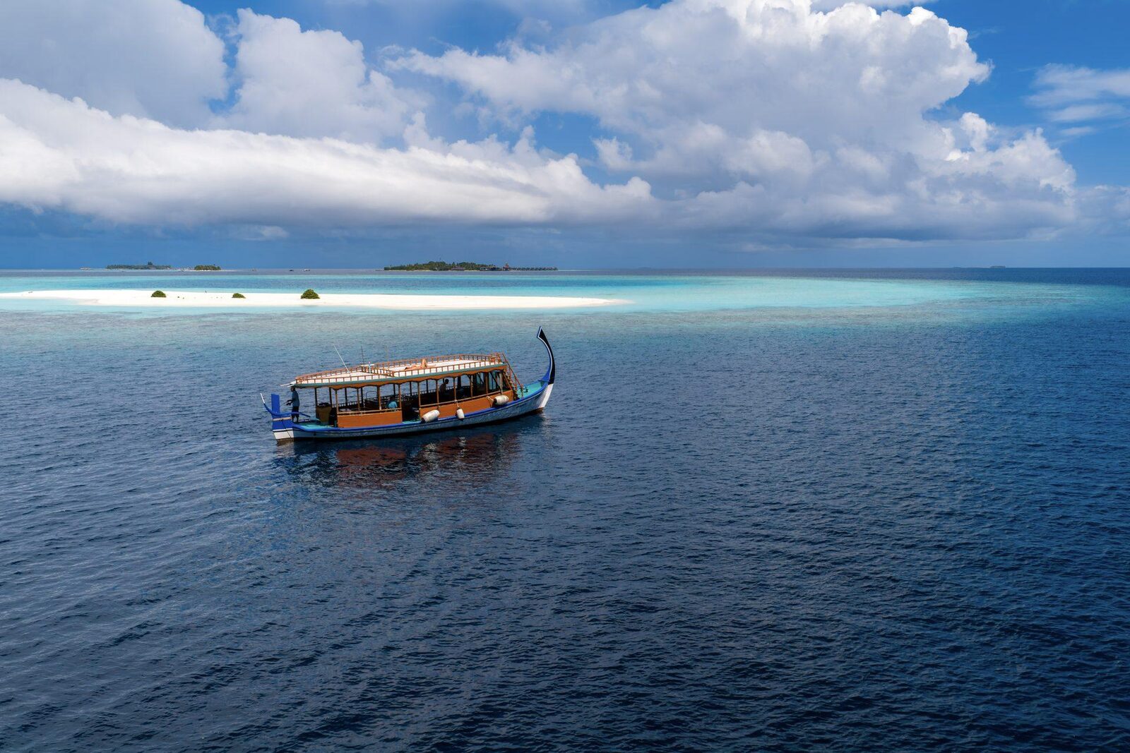 A traditional Maldivian dhoni anchored on turquoise water off Dhigurah